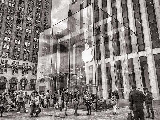 أشخاص يقفون خارج متجر Apple Store الزجاجي