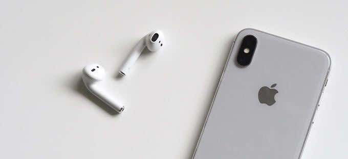 زوج من سماعات Apple AirPods بجوار جهاز iPhone